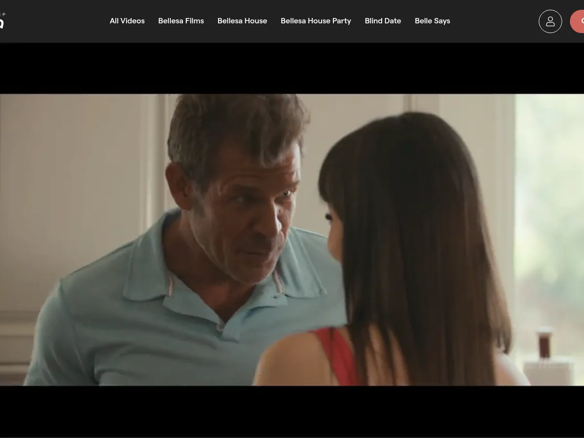 A heavily blurred, censored capture of the BellesaPlus homepage โ only soft shapes are visible, no explicit or readable content